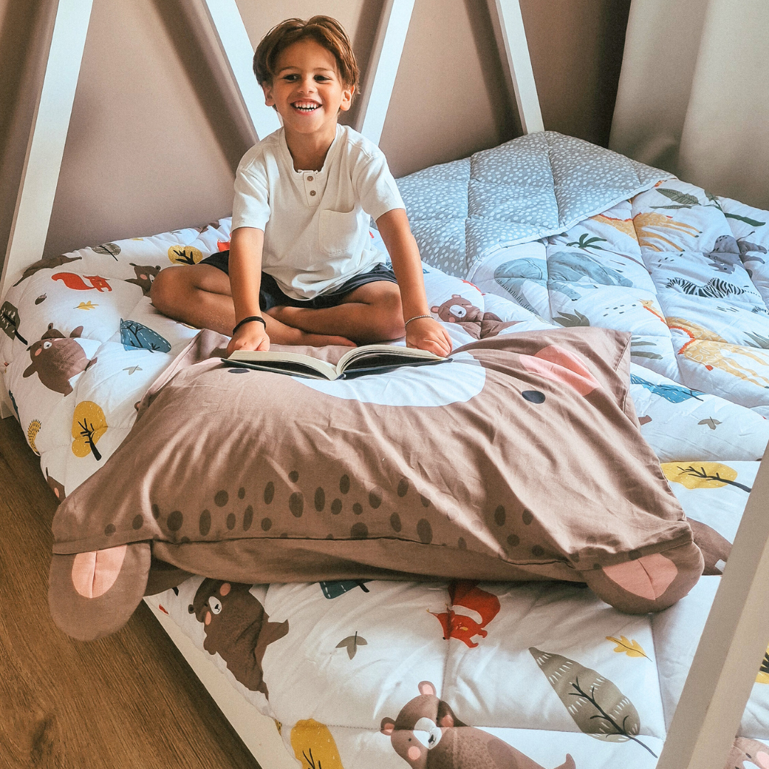 Thehappybed Kids - Bobby Bear 100% cotton year-round duvet, child smiling on bed with bear-themed bedding.